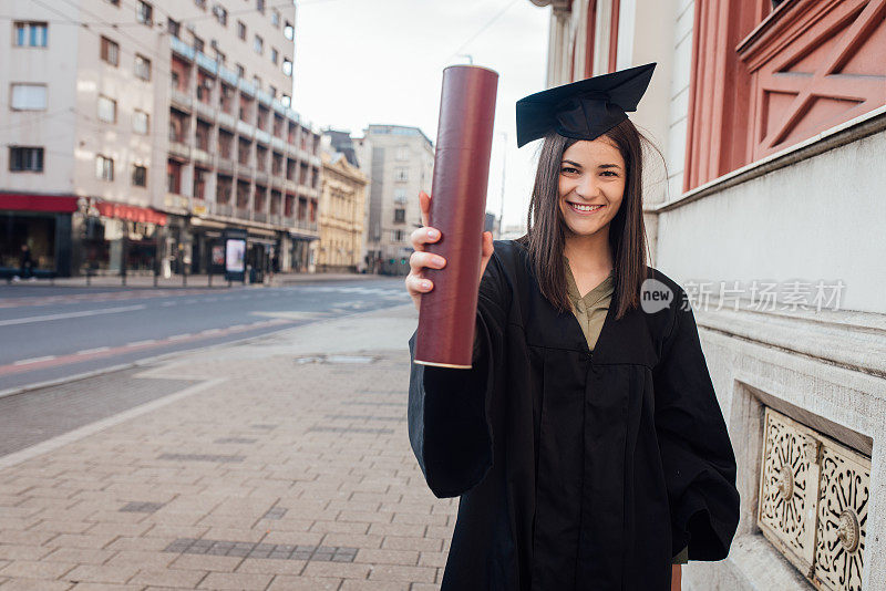 一位美丽的大学毕业生展示她的毕业证书的画像