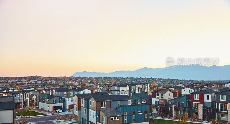 美国西部的住宅社区与现代住宅在日出和山脉的背景