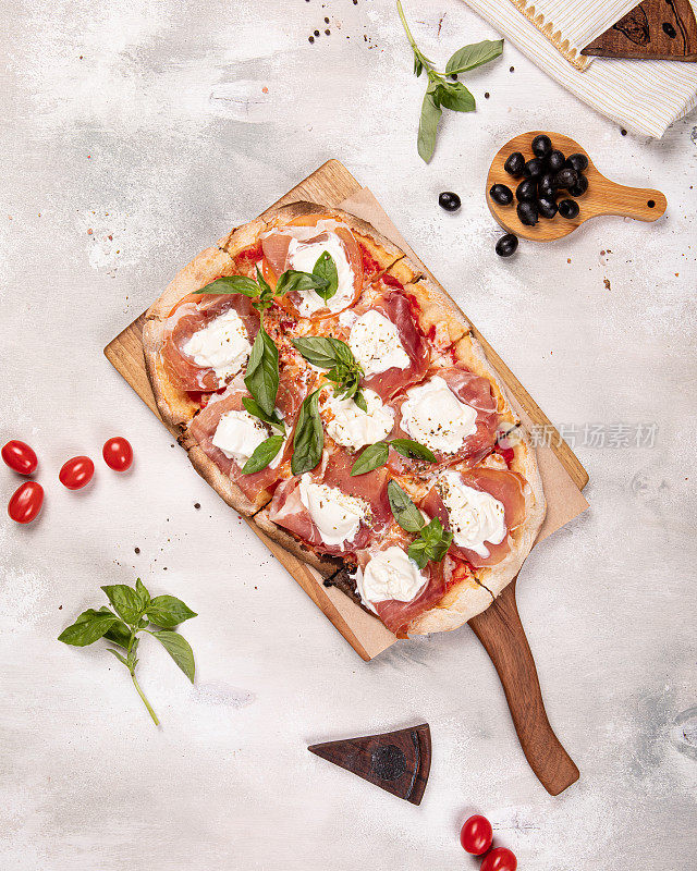 意大利罗马矩形披萨，意大利熏火腿和马苏里拉奶酪在木板上，白色乡村背景
