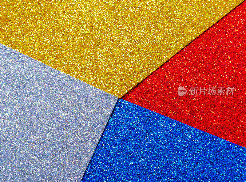 银黄色红蓝色包装纸底色带有金属光泽。多色银黄红蓝闪亮纸背景