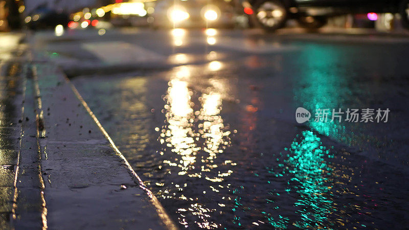 灯光反射，雨天道路。雨点，潮湿的城市街道沥青