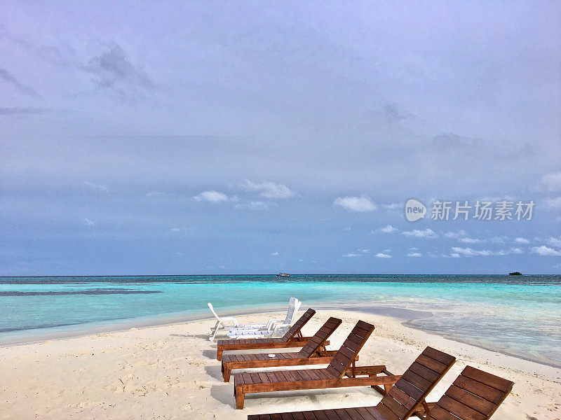 完美的白色热带岛屿天堂海滩与太阳躺椅在马尔代夫