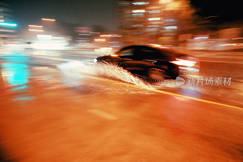 在潮湿天气的夜晚，汽车在水中快速行驶