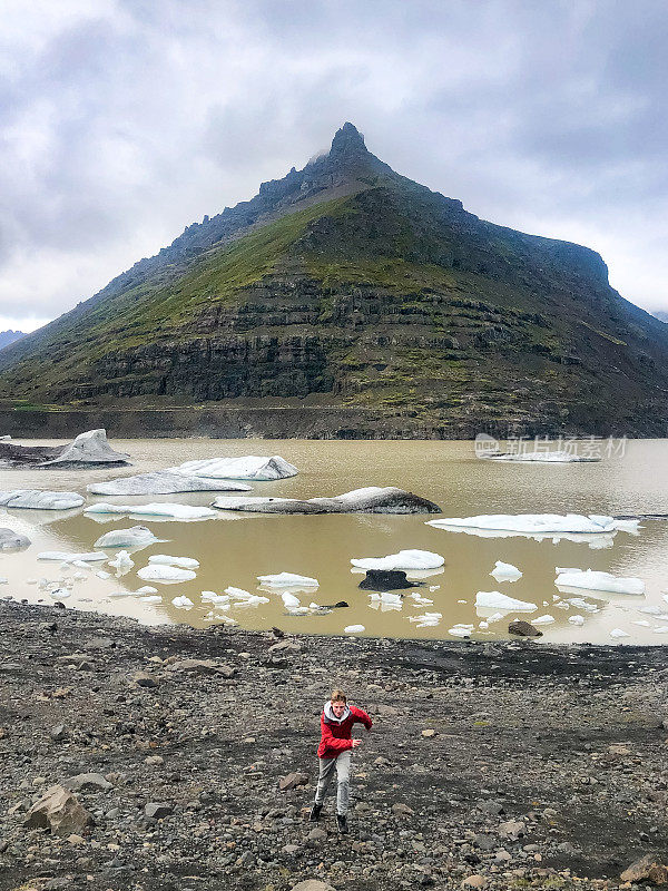 十几岁的男孩跑上山，后面是冰湖和山峰