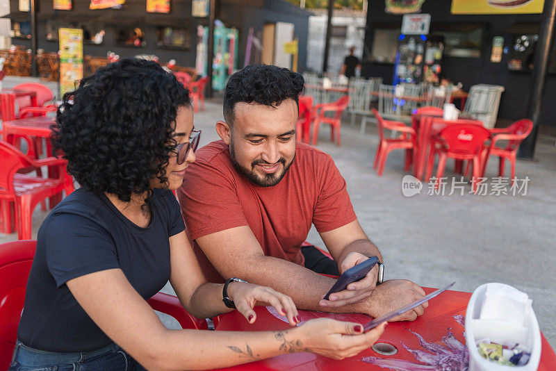 一对年轻夫妇用智能手机扫二维码就能看到餐厅菜单
