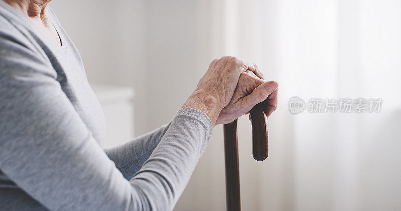 退休后，手和老年妇女用手杖辅助行走，协助老年人或运动残疾。养老保健、老年护理、养老院患者用拐杖放松