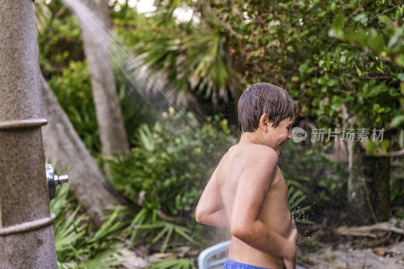 快乐的少年在室外海滩淋浴冲洗