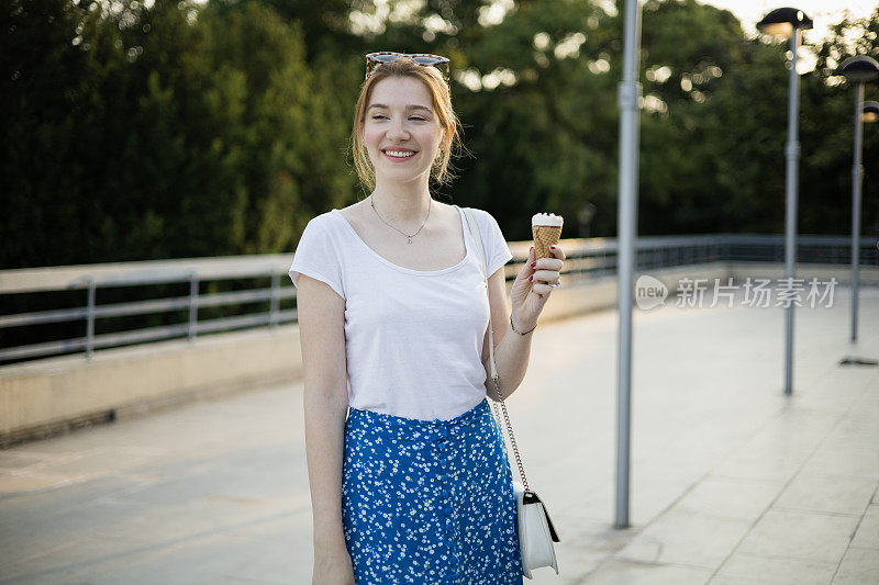 一个美丽的年轻女子在户外享受冰淇淋的肖像