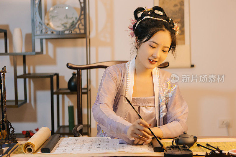 亚洲汉服美女用平板电脑用画笔画画