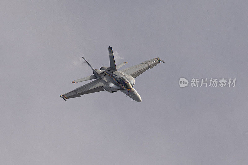 F-18大黄蜂高G机动俯视图，机翼根部和垂直稳定器处有凝结条纹