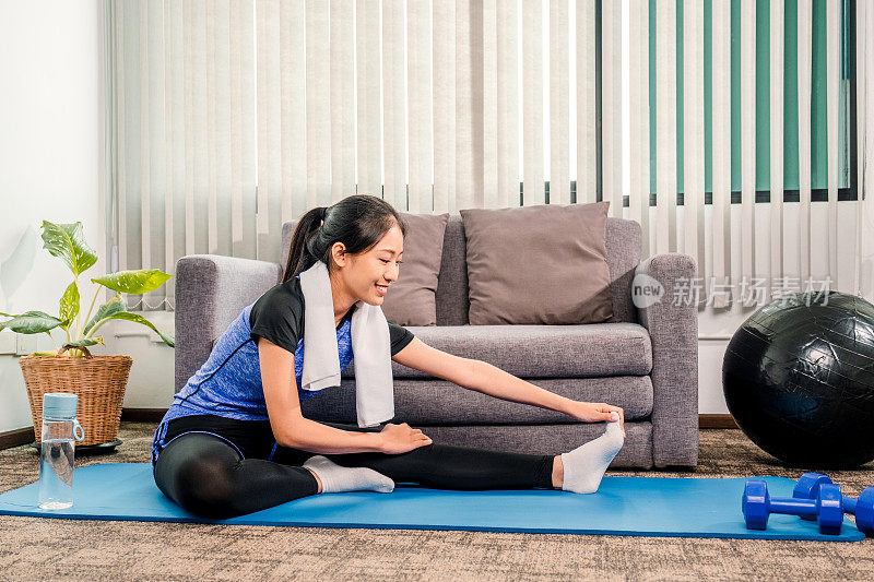 年轻的亚洲健康女性在家里做瑜伽锻炼