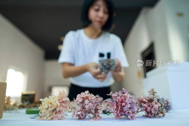 一位女花艺教师正在用绣球花制作花圈