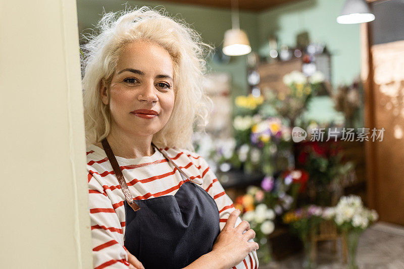 花店工作人员在花店靠在墙上看着镜头