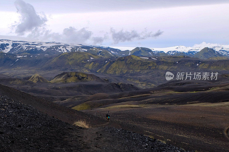 崎岖的山路，被风景如画的白雪皑皑的山峰包围:冰岛的劳加维古尔步道