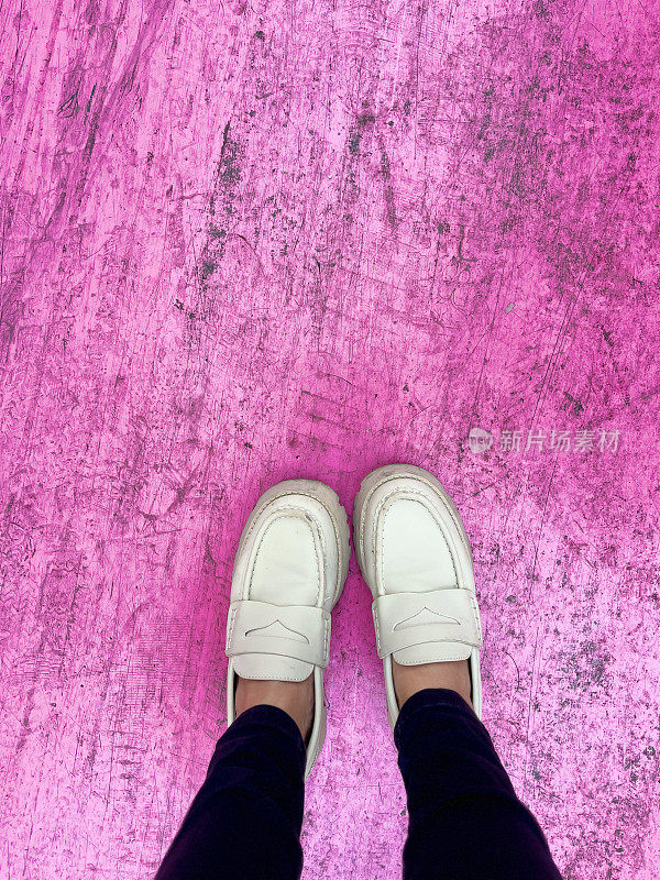 脚踩在粉红色的地板上