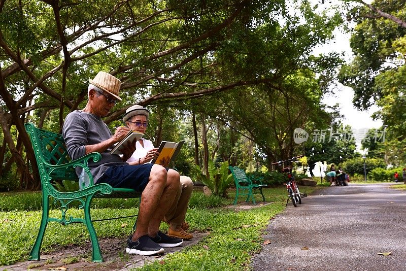 退休后的生活方式，一对老夫妇在公园里看书。
