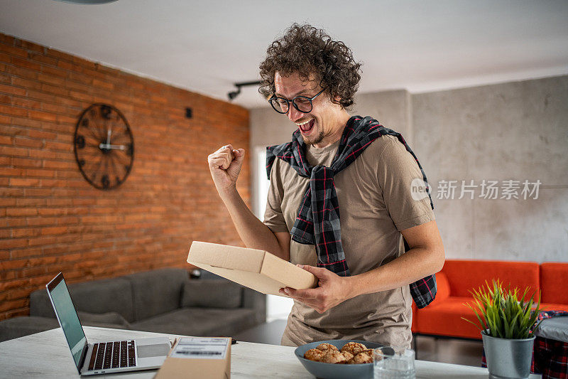 一名开心的白人男子刚刚收到了他在网上订购的包裹