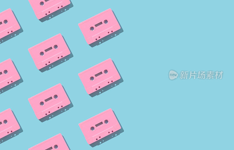 图案制成的复古粉红色的音频磁带浅蓝色的背景。复古科技的创意理念。80的审美。老式音频盒式磁带模式的想法。复古的怀旧。平的。