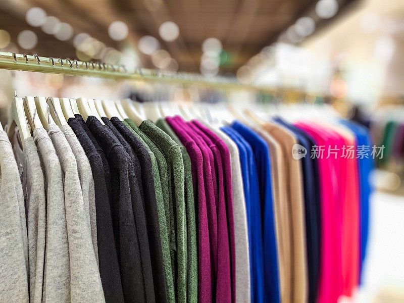 挂在服装店衣架上的女装针织品和五颜六色的毛衣