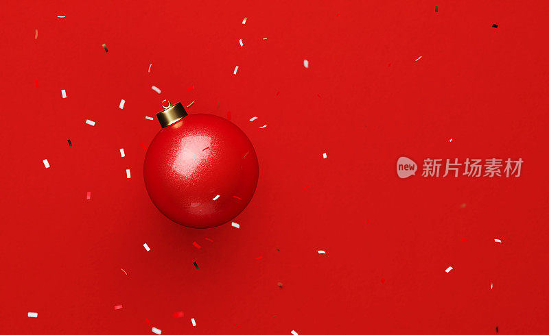 圣诞节概念-五彩纸屑落在红色的小玩意在红色的背景