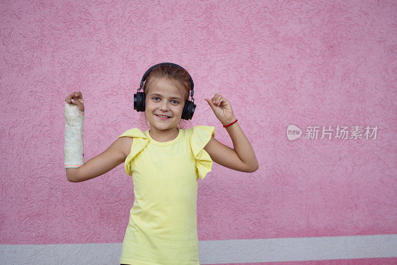 微笑的可爱小女孩的肖像，戴着破碎的耳机