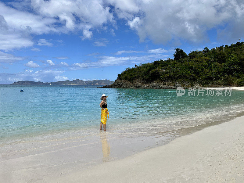 一位年长的妇女站在水里微笑着回头望着Trunk湾圣约翰岛的海岸