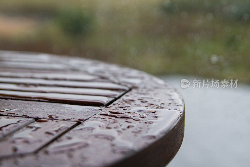 阳台上的一张桌子，被雨水打湿了。水滴特写