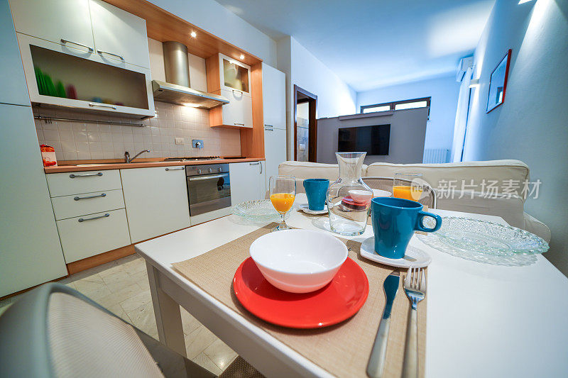 一房一床早餐公寓，白色室内设计，开放式空间:厨房带餐桌，客厅带沙发