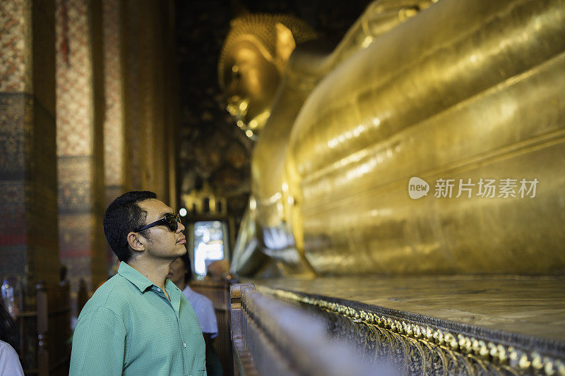 亚洲游客站在泰国曼谷卧佛寺的金卧佛雕像前