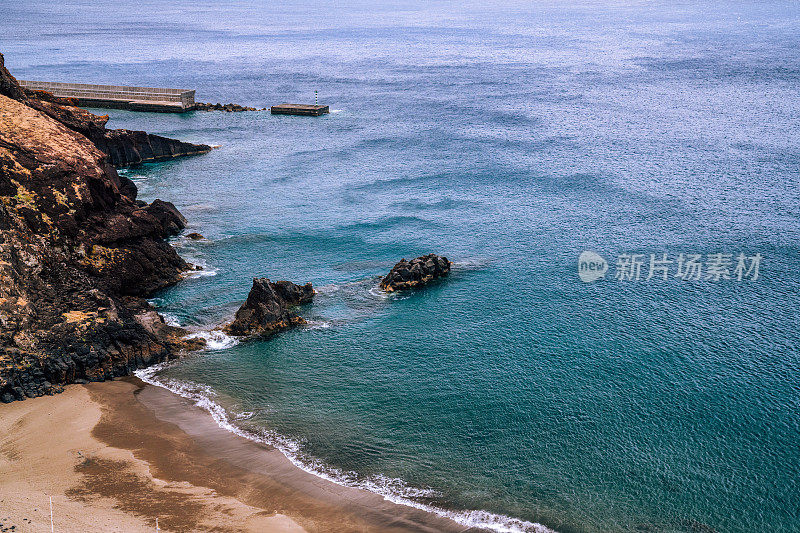 海边的石崖和沙滩。马德拉岛的天然海岸线