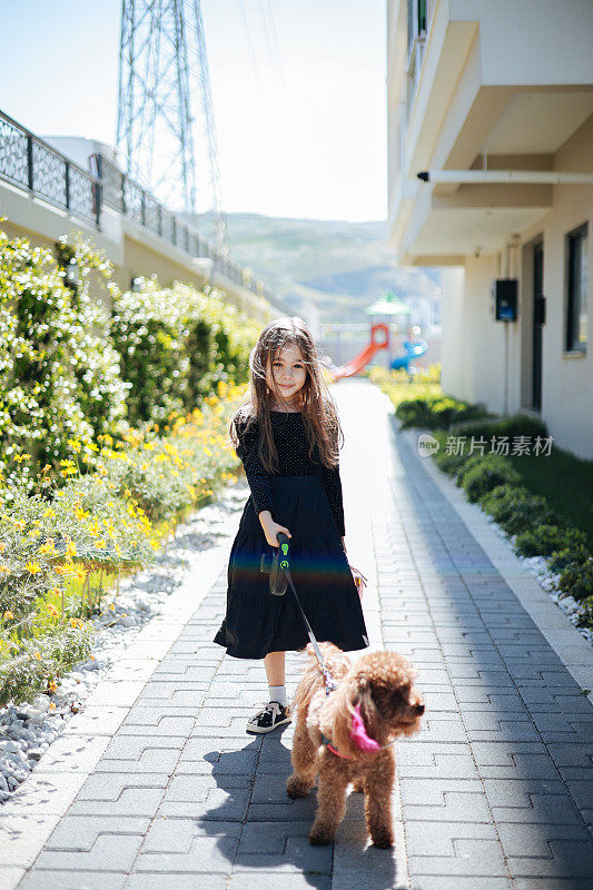 一个可爱的小女孩在外面散步，和她的狗狗亲密无间
