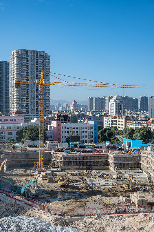 有垂直停车机器和远处城市建筑的建筑工地