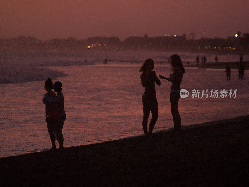 日落时分，人们在海滩上互动
