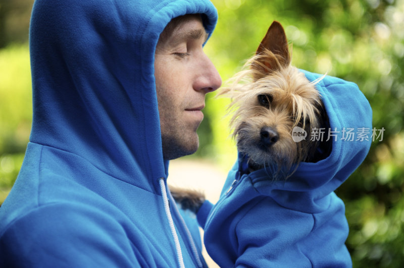 年轻人最好的朋友狗搭配蓝色帽衫户外公园