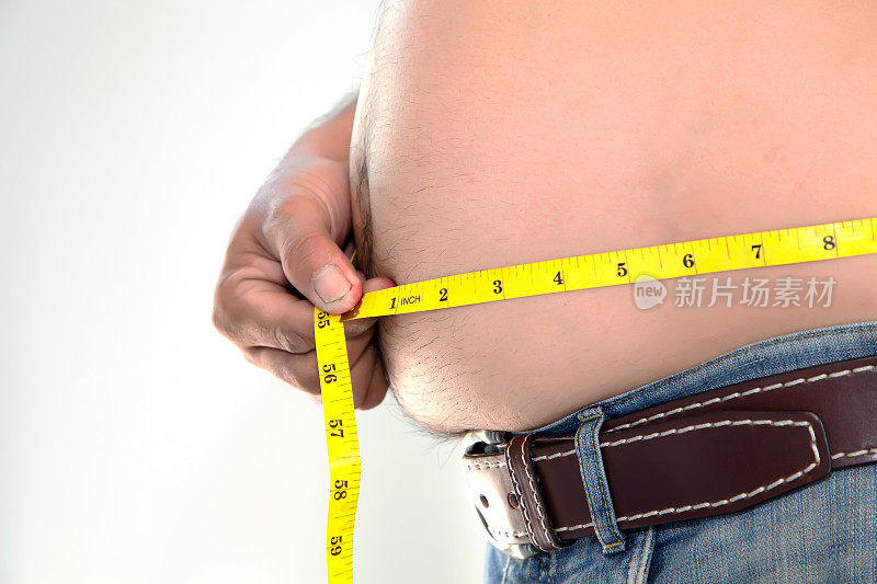 肥胖的人在测量他的肚子。