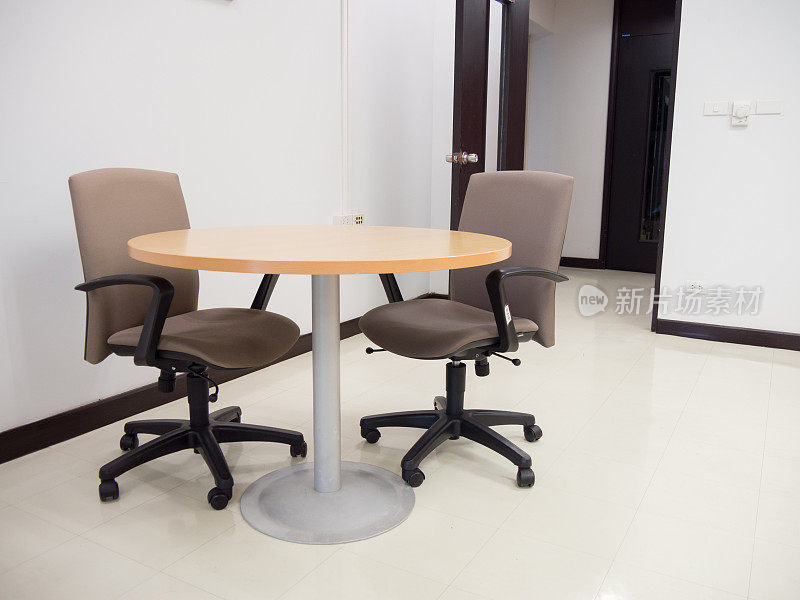 宽阔的镜头与圆桌和舒适的椅子空会议室准备会议或业务讨论