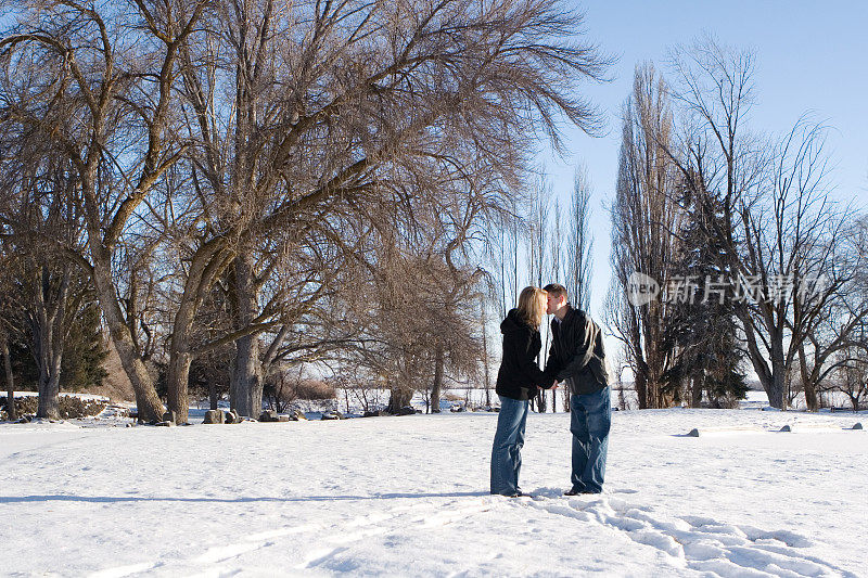 一对情侣在冬天的雪中接吻