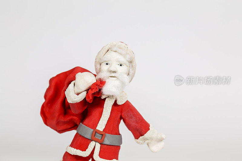 手工粘土圣诞老人，携带礼物袋，在白色的背景