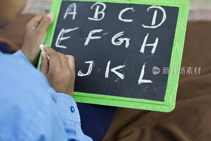 男孩在学校的石板上写字