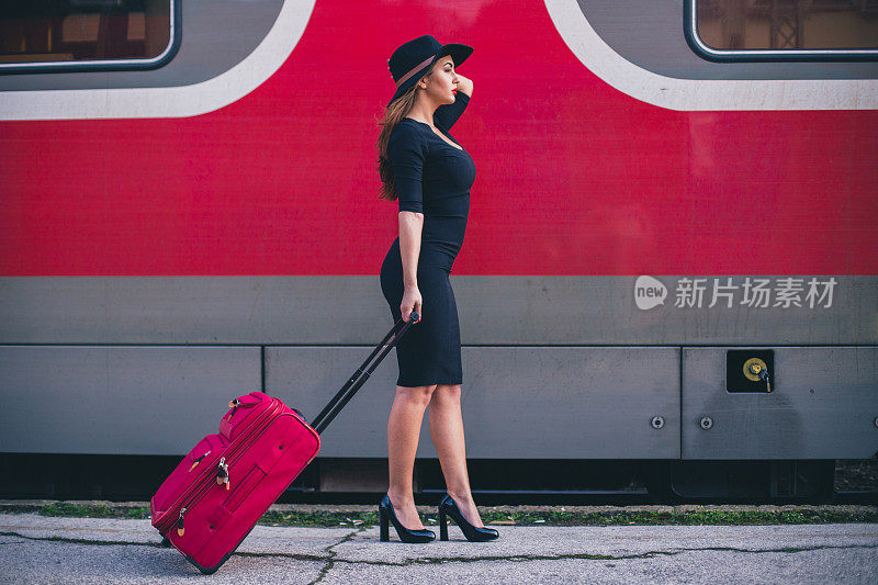 在火车站提着行李的漂亮女孩