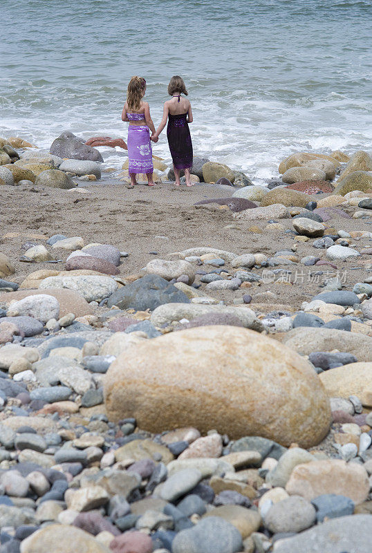 小女孩们在海滩上手拉手