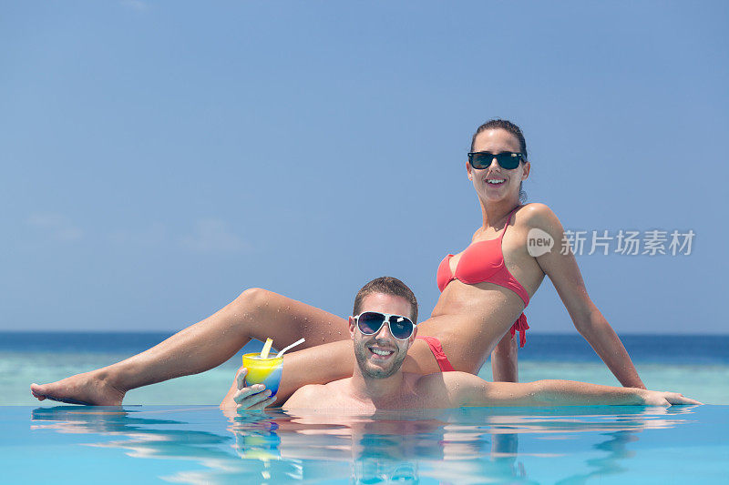 年轻夫妇放松海滩游泳池