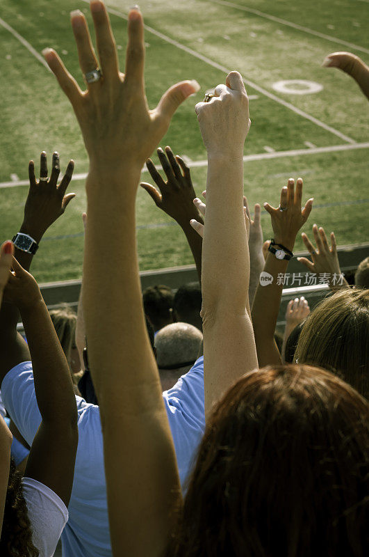 球迷举起手臂为他们的球队欢呼