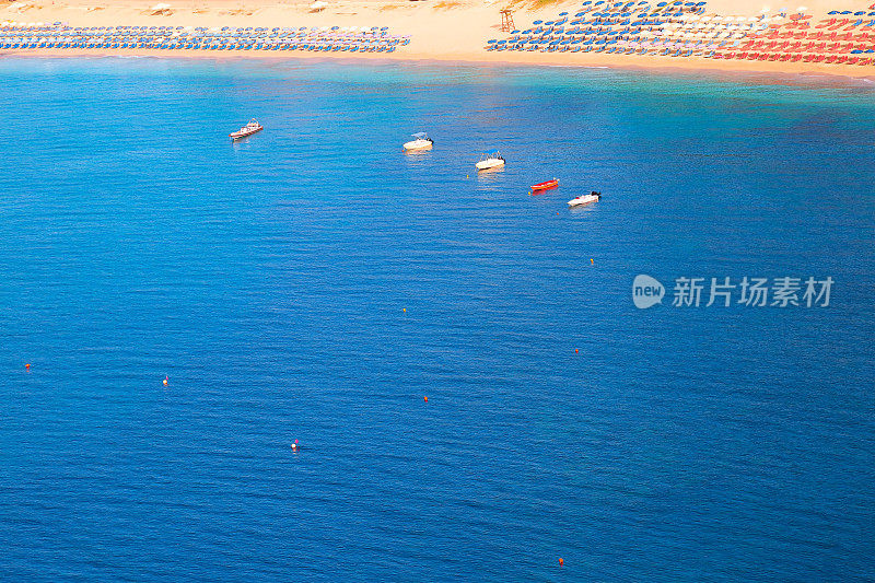 小船，海滩和宁静的蓝色海浪