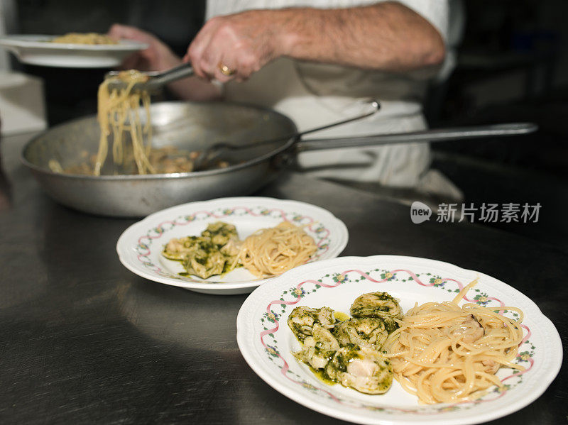 在意大利厨房里，厨师们把意大利面放在盘子里