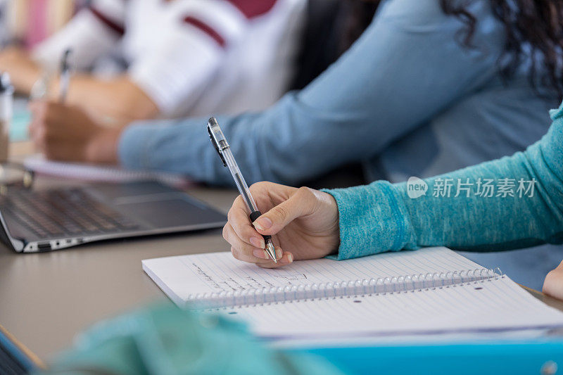 一位面目全非的女大学生在课堂上做笔记