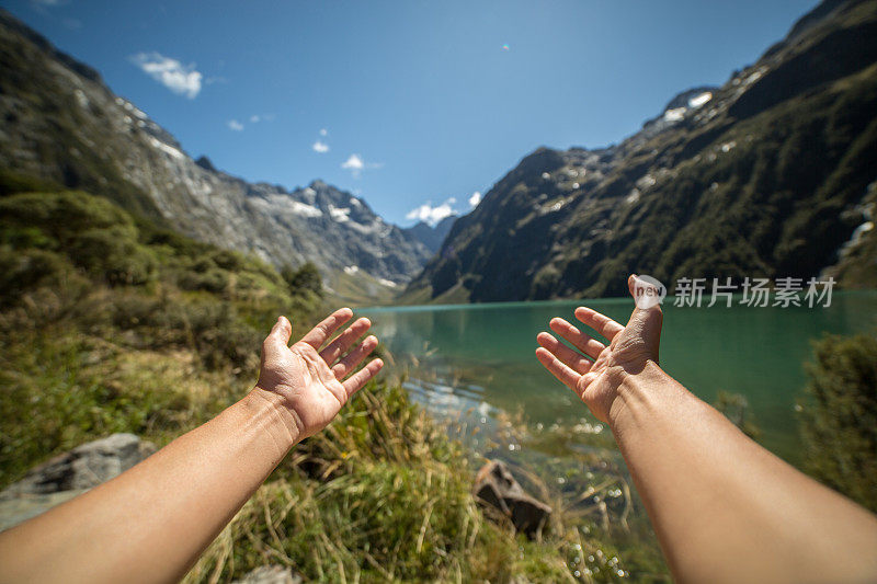 个人视角的女人的双臂伸向山湖