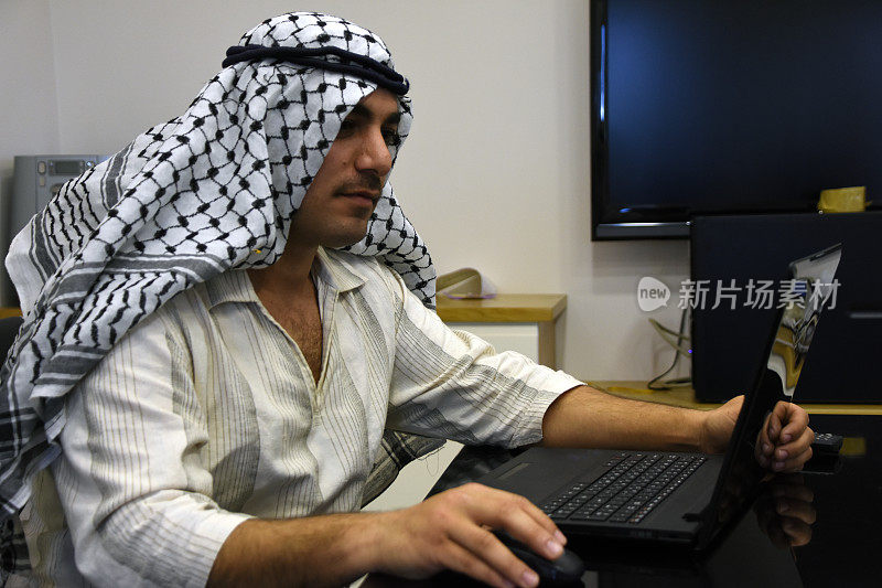 年轻的阿拉伯人在会议室使用笔记本电脑