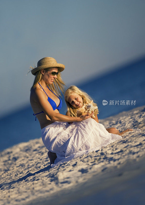 美丽的母亲和女儿在海滩上