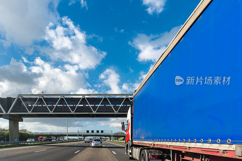 在高速公路上超过一辆蓝色大卡车